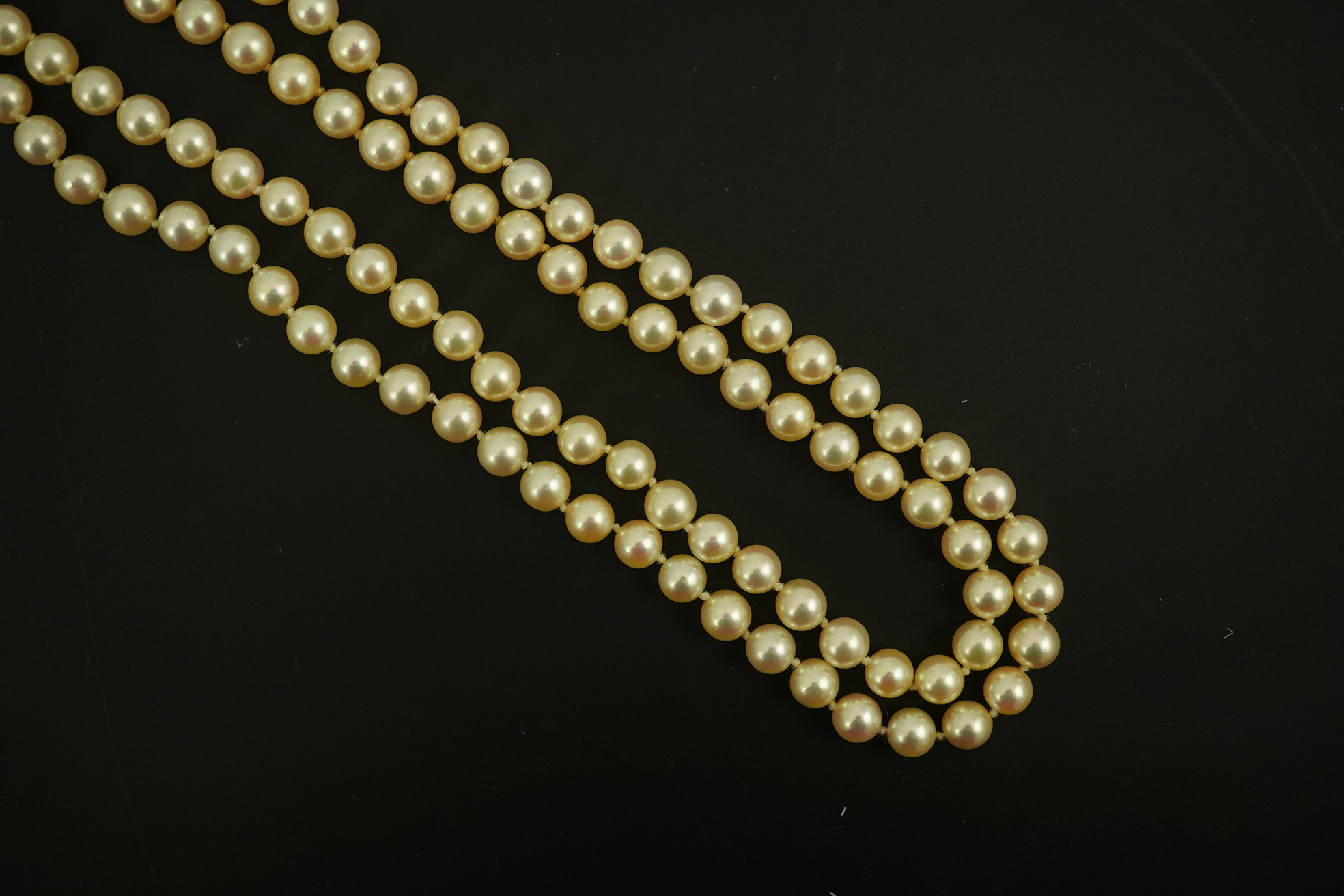 A modern double strand cultured pearl necklace, with 18k gold and diamond set twin ring clasp